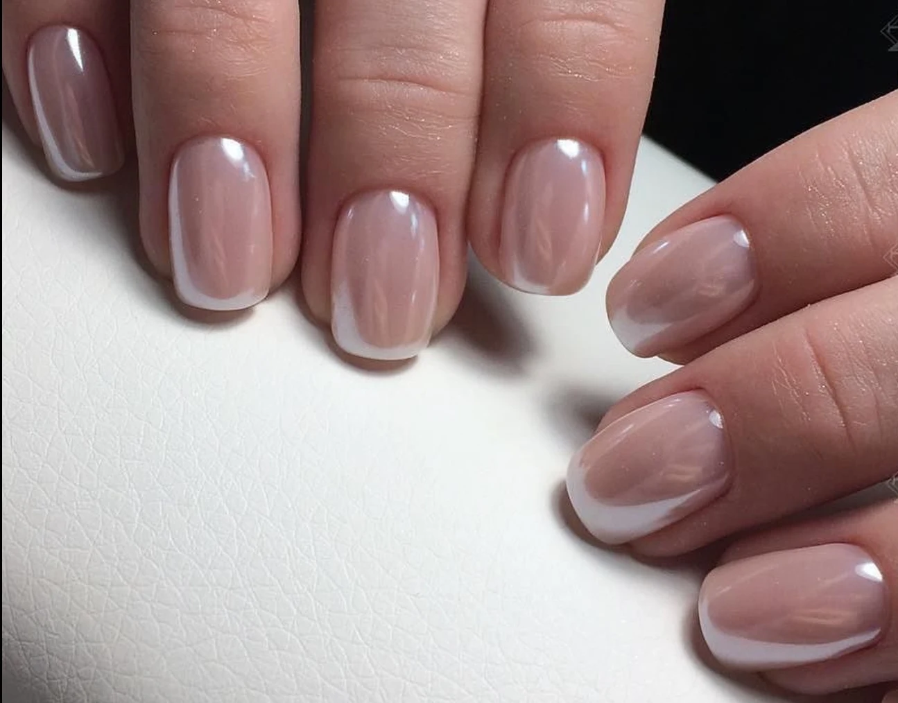 Short squoval nails in a sheer nude with a soft pearl French tip